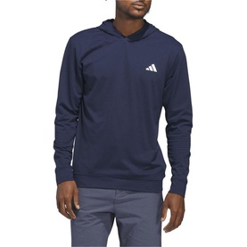 Model wearing Adidas Golf hoodie in Collegiate Navy, featuring kangaroo pocket and three-bar logo, styled with grey trousers.