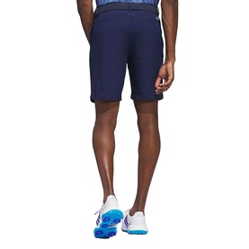 Model wearing Adidas Golf shorts in Collegiate Navy, styled with blue and white golf shoes, rear view.