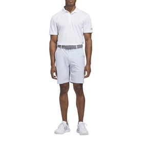 Model wearing Adidas Golf Crystal Sky shorts with white polo shirt and white trainers, full-length front view.