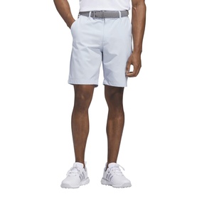Model wearing Adidas Golf Crystal Sky shorts with white belt and white trainers visible.