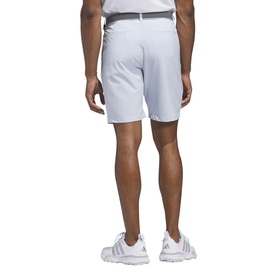 Model wearing Adidas Golf Crystal Sky shorts, rear view, styled with a white polo shirt and white trainers.
