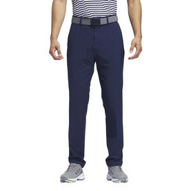 Model wearing navy slim-fit trousers with belt, styled with a striped polo shirt and white trainers