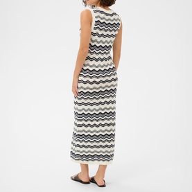 Model wearing Kaffe dress in Chalk/Midnight wavy stripe knit, sleeveless maxi length, shown from behind, styled with black flat sandals.