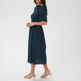 Model wearing Kaffe midi dress in Midnight Marine, short sleeves, smocked waist, relaxed skirt, styled with nude mule heels
