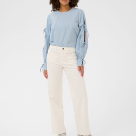 Model wearing Kaffe chalk wide-leg trousers, paired with a light blue long-sleeve top with tie-detail sleeves.