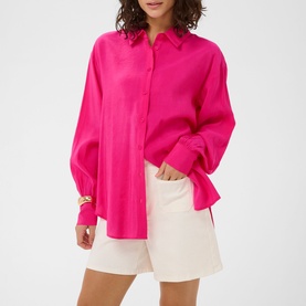 Model wearing Kaffe beetroot purple oversized satin shirt with white mini shorts and gold cuff bracelet