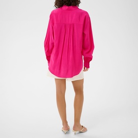 Model wearing Kaffe Beetroot Purple oversized shirt, back view, styled with white mini shorts and silver flat sandals.