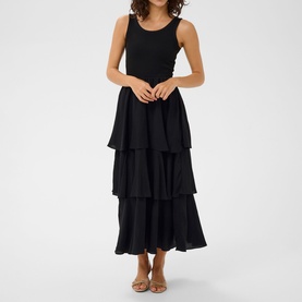 Model wearing Kaffe black deep sleeveless tiered maxi dress with ruched bodice and layered skirt, styled with tan sandals