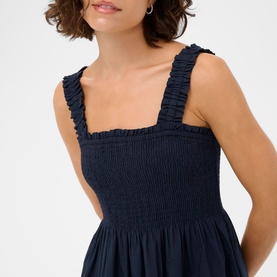 Model wearing Kaffe Midnight Marine dress with shirred bodice, ruffle straps and square neckline