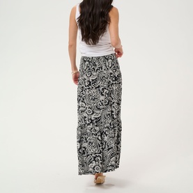 Model wearing Kaffe Black Chalk Paisley maxi skirt, rear view, styled with a white sleeveless top.