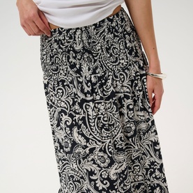 Model wearing Kaffe Black Chalk Paisley maxi skirt with white top, featuring allover paisley print and elasticated waist.