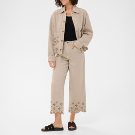 Model wearing Kaffe Feather Gray broderie anglaise wide-leg trousers, styled with matching jacket and black top, black flat sandals.