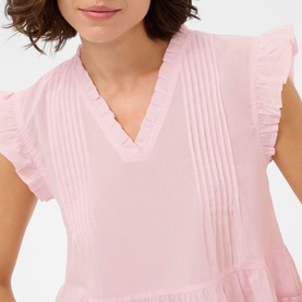 Model wearing Kaffe dress in Ballerina pink, featuring V-neck, ruffle sleeves and pintuck front detail, close-up view