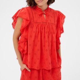Model wearing Kaffe Poppy Red broderie anglaise frill-sleeve blouse with tie neck, styled with matching red wide-leg trousers