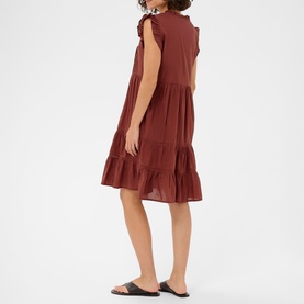 Model wearing Kaffe henna tiered mini dress with ruffle shoulders and hem, styled with black flat sandals