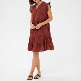 Model wearing Kaffe henna tiered mini dress with flutter sleeves and V-neckline, styled with tan flat sandals