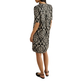 Model wearing Hobbs black and cream baroque print knee-length dress with elbow-length sleeves, back view, styled with black flat shoes.