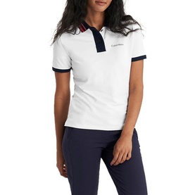 Model wearing Calvin Klein Golf white polo shirt with navy and red tipped collar and cuffs, paired with navy trousers.