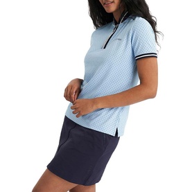 Model wearing Calvin Klein Golf Blue Bell polo shirt with zip neckline and stripe cuffs, styled with navy mini skirt