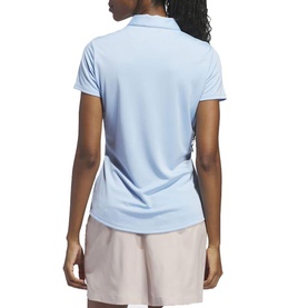 Model wearing Adidas Golf women's polo shirt in Clear Sky blue, short sleeves, back view, styled with pink shorts.
