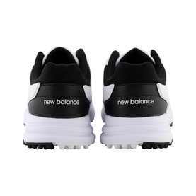 New Balance golf shoes in black and white, shown from rear angle, with white rubber studded sole and branded heel tab