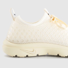 Nike trainer in Muslin and Pale Ivory with textured knit upper, ribbon lace detail, and cream midsole, close-up heel and side view