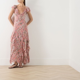 Model wearing Rixo Butterfly Paisley Orange silk maxi dress with ruffle trim, V-neckline and flutter sleeves, styled with flat sandals