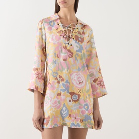 Model wearing Rixo Bloom Yellow floral mini dress with lace-up neckline, bell sleeves and pink, blue and yellow print