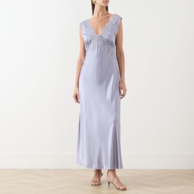 Model wearing Rixo dusty blue maxi dress with V-neckline, lace trim detail and side splits, styled with nude heeled sandals.