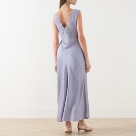 Model wearing Rixo dusty blue maxi dress, rear view showing deep V-back with lace embroidery detail and fluid satin-finish skirt.