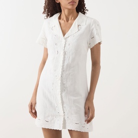 Model wearing Rixo Zayanna Embroidered Mini Dress in ivory, featuring notched lapels, short sleeves, button fastening and broderie detailing