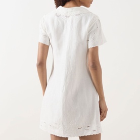 Model wearing Rixo Zayanna Embroidered Mini Dress in ivory, back view showing broderie anglaise detailing and short sleeves.