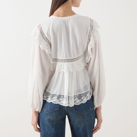 Model wearing Rixo top in Lilly Embroidery Ivory, back view, with lace trim, ruffle details, and balloon sleeves, styled with blue jeans.