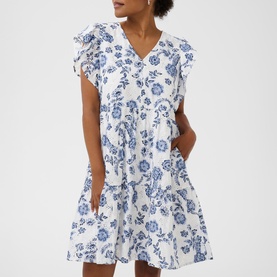 Model wearing Kaffe dress in Chalk Midnight Flower, white with blue floral print, ruffle cap sleeves, V-neck, tiered skirt with pockets
