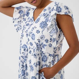 Model wearing Kaffe dress in Chalk Midnight Flower, white with blue floral print, frill cap sleeves, V-neck and elasticated waist