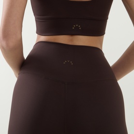 Model wearing Varley Coffee Bean leggings, rear view, with matching sports bra. High-waisted fit with small logo detail.