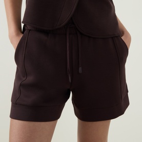 Model wearing Varley Coffee Bean shorts with drawstring waist and side seam detail, styled with matching top