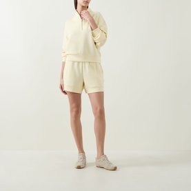 Model wearing Varley Anise Flower shorts with matching sweatshirt and beige trainers