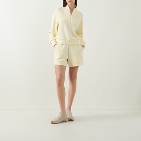 Model wearing Varley Anise Flower sweat top with matching shorts and beige trainers