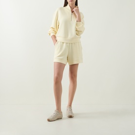 Model wearing Varley Anise Flower sweat top with matching shorts and beige trainers.