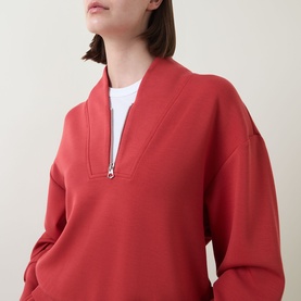 Model wearing Varley Davidson Half-Zip Sweatshirt in bossa nova, featuring bomber collar and half-zip fastening, styled with white top underneath.