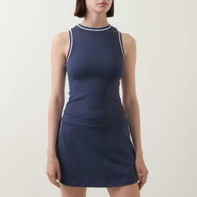 Model wearing Varley Blue Nights tank with white tipped neckline and armholes, styled with matching navy mini skirt.