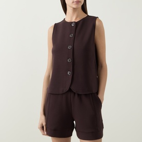 Model wearing Varley Coffee Bean sleeveless button-front vest top, styled with matching shorts.