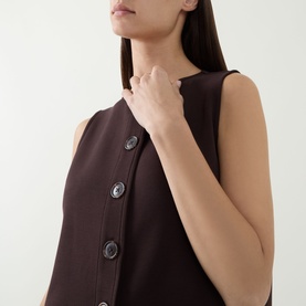 Model wearing Varley Coffee Bean sleeveless top with asymmetric diagonal button placket detail, cropped close-up view.