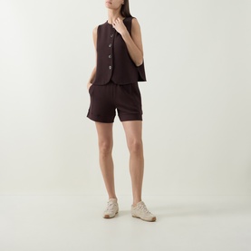 Model wearing Varley top in Coffee Bean, styled with matching shorts and white trainers