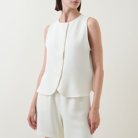 Model wearing Varley sleeveless top in Pristine white with button front detail, styled with matching wide-leg trousers.