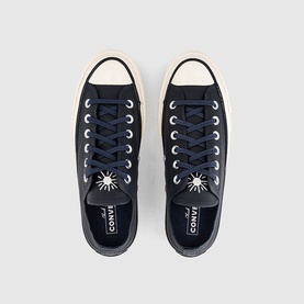 Converse Chuck Taylor low-top trainers in navy canvas with cream sole, silver eyelets, and star ankle patch, overhead view