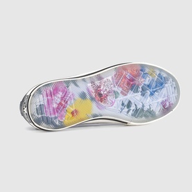Trainer sole view showing floral print insole in pink, yellow and blue tones with white rubber outsole