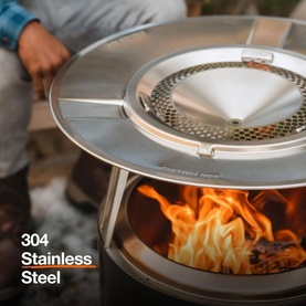 Solo Stove Bonfire Heat Deflector in 304 stainless steel, fitted over a fire pit with visible flames, shown in outdoor setting.