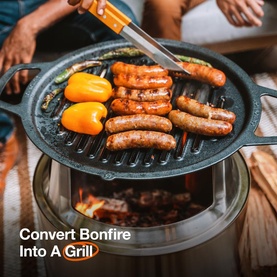 Solo Stove Cast Iron Bonfire Grill Top and Hub in use, cooking sausages and peppers on a round ridged cast iron grill plate over a fire pit.